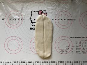 11、松弛好的面团擀成牛舌状，用竹签在中间压一道印。