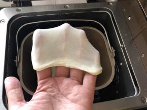 8、将水倒入面粉中启动面包机的揉面功能20分钟，面团达到非常好的延展性。