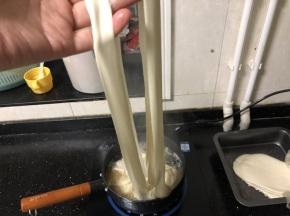 17、把面胚抻长后从中间的压痕一分为二，放入锅中。