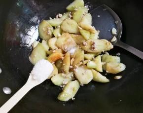 放入一小勺糖，翻炒均匀，放少许热水