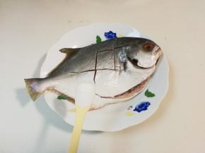 金昌鱼去掉鱼肠，里外刮洗干净，划切数刀，放入一小勺抹匀腌制一小时