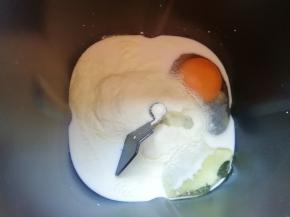 面包机桶内先倒入牛奶，接下来打入鸡蛋，然后依次加入细砂糖和盐(糖和盐对角放)，加入奶粉，加入玉米油。