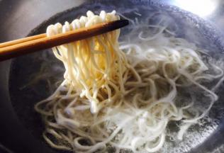 捞出面条盛在碗中，然后再面上浇上肉末香菇酱，吃的时候拌一拌。