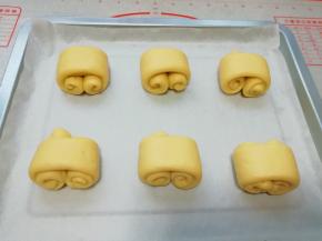 烤盘上铺油纸，放上做好的面包卷生胚。