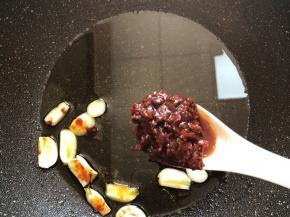 锅中放油烧热，蒜瓣放进去加1汤匙红油豆瓣酱翻炒出红油