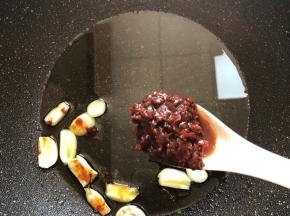 锅中放油烧热，蒜瓣放进去加1汤匙红油豆瓣酱翻炒出红油