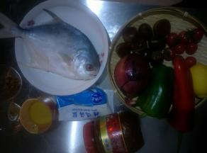 准备食材，金昌鱼去内脏去鳃洗净，在背部每隔2厘米处斜着划几刀。圆葱洗净切几个洋葱圈，其余的切块，青红甜椒洗净，柠檬加适量盐洗净，千禧西红柿洗净。