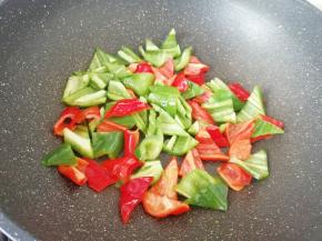 锅底留余油，下入青红椒翻炒一分钟左右。