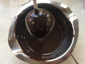 滚好的蛋糕，要停放一会，让多余的巧克力滴下去，之后将巧克力擦在板子上，等待巧克力完全凝固
