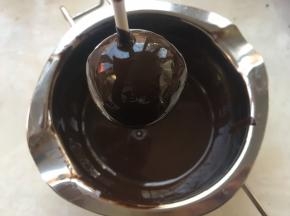 滚好的蛋糕，要停放一会，让多余的巧克力滴下去，之后将巧克力擦在板子上，等待巧克力完全凝固
