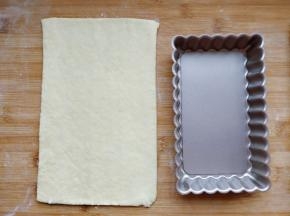 取一块面团，在案板上擀成3mm厚的薄片，切出比模具稍大的尺寸。同时预热烤箱，上下火180度，10分钟。