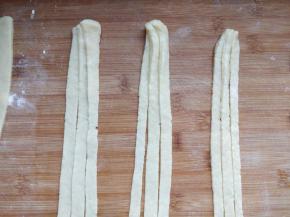 取一块儿面团擀成薄片，切成均匀的细条。