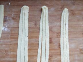 取一块儿面团擀成薄片，切成均匀的细条。