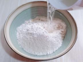 分次加入开水。边倒开水边用筷子挑成絮状。（切记不要一下子将开水倒入）