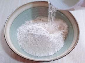 分次加入开水。边倒开水边用筷子挑成絮状。（切记不要一下子将开水倒入）