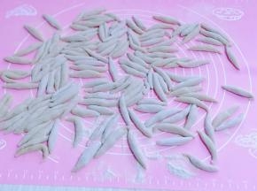 取一块面。用手心来回搓，搓成鱼鱼状，依次做完。