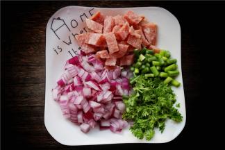 处理一下食材。培根不需要解冻，切成小片，蒜薹洗净切成小段，圆葱也切碎，法香切末。