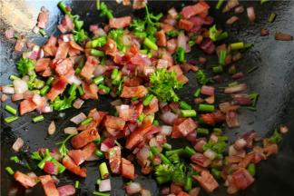 培根煸炒一小会出油后，再把准备好的圆葱、蒜薹和法香碎放进去翻炒出香味来。