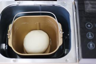 和好的面团用手揉圆后继续放入面包桶里进行醒发。