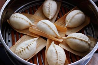 蒸锅里倒入适量的清水后，把包好的包子放入蒸屉上进行二发。