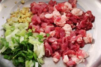 猪肉用刀切成小丁，葱姜切末后，把切好的猪肉和葱姜都放入盆中。