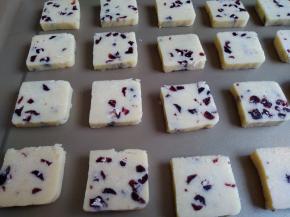 将冷冻好的饼干切成小块，放在不粘烤盘上