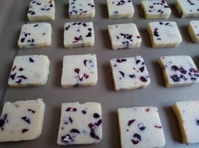 将冷冻好的饼干切成小块，放在不粘烤盘上