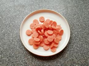 面团发酵的时间里准备披萨馅料。
火腿肠去掉外包装切成片。