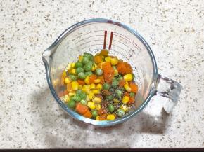 6.把蔬菜丁焯熟，可以选择自己喜欢的菜，我选择的是胡萝卜豌豆和玉米，撒少许黑胡椒和盐