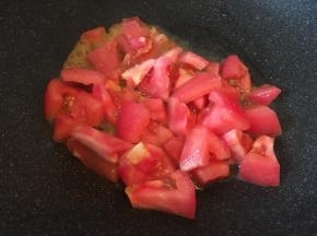 热锅热油放入番茄块，翻炒至番茄变软。