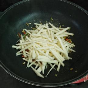 接着加入地瓜条，大火翻炒一分钟，时间不用过久，地瓜生的也能吃，炒一分钟就可以了，清脆