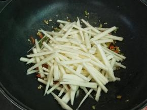 接着加入地瓜条，大火翻炒一分钟，时间不用过久，地瓜生的也能吃，炒一分钟就可以了，清脆