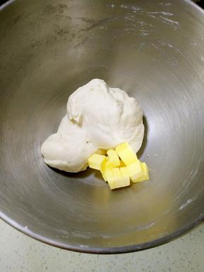 面团揉出厚膜放入软化的黄油。