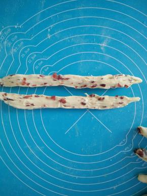 取一个面团，用手稍微搓长，从中间横切成两半。