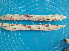 取一个面团，用手稍微搓长，从中间横切成两半。