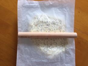 将牛轧糖放入模具中，上面放一张油纸，用擀面棒擀均匀