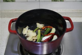 然后再将姜片及辣椒干下锅，一并煎出味。