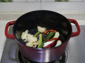 然后再将姜片及辣椒干下锅，一并煎出味。