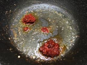 留底油加入郫县豆瓣酱和白糖炒出红油来