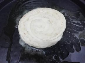 电饼挡中加入适量的油预热，预热好后把按扁的饼放入电饼铛中