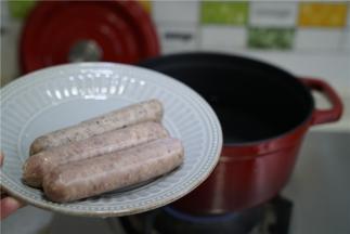 锅里加水煮开，将香肠先下锅煮个三分钟。