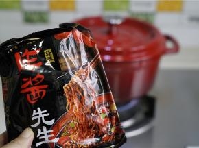 珐琅锅里加水煮开，炸酱面的料包取出，将面下锅，焖煮三分钟。珐琅锅密封性好，不用煮太长时间。