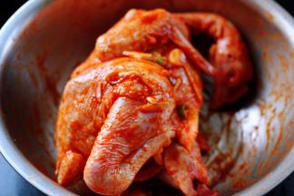 再用手把鸡按摩一遍，记住把葱姜蒜放到鸡的肚子里面一些，这样烤出来的味道才会更好吃哦，打上保鲜膜放入冰箱冷藏过夜。