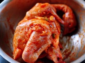 再用手把鸡按摩一遍，记住把葱姜蒜放到鸡的肚子里面一些，这样烤出来的味道才会更好吃哦，打上保鲜膜放入冰箱冷藏过夜。