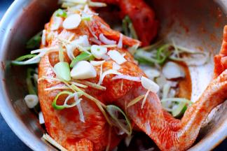 这个时候把用刀切好的葱花，大蒜和姜片撒在鸡的身上。