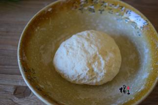 面粉中缓慢加入清水，一边倒一边用筷子搅拌成絮状，再用手揉成光滑的面团，盖上保鲜膜静置30分钟