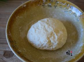 面粉中缓慢加入清水，一边倒一边用筷子搅拌成絮状，再用手揉成光滑的面团，盖上保鲜膜静置30分钟