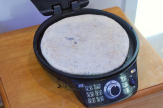 电饼铛里倒一点油，选择5档最高火，放入饼胚烤3分钟。