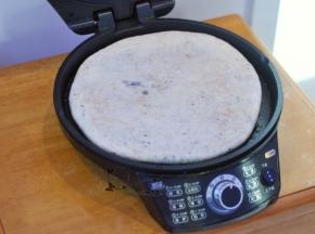 电饼铛里倒一点油，选择5档最高火，放入饼胚烤3分钟。