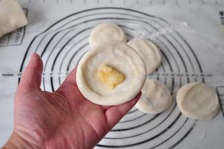 配好的面团分割成小段轻按扁。我一般分割成55-60克的面团，这个大小正好适合我家的锅，拿着食用起来也方便。